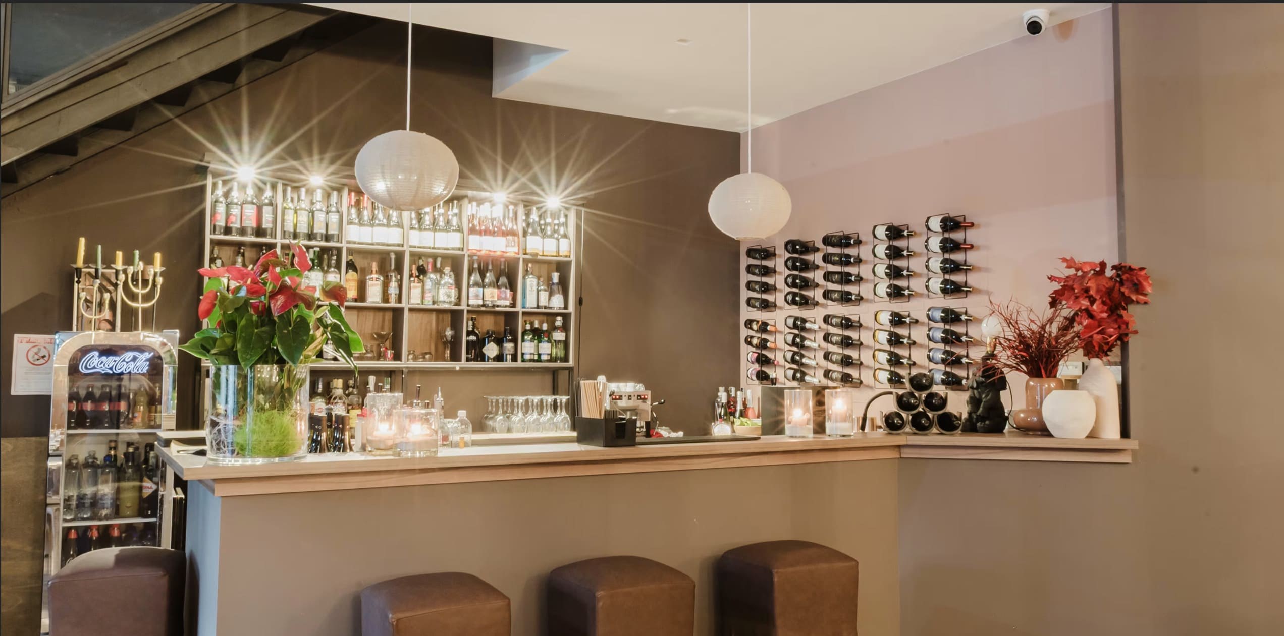 Il bancone del bar con la parete delle bottiglie e le etichette in rastrelliera